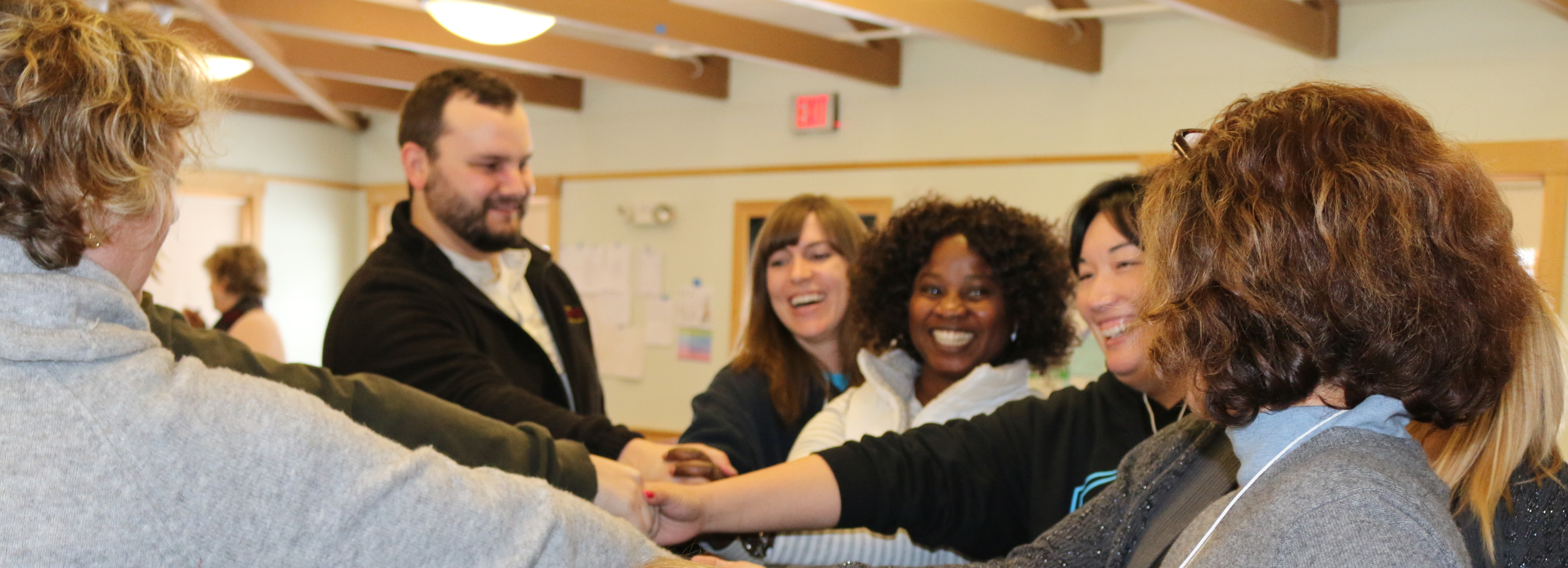 NH Leadership Series graduates gather in a circle with their hands centered in anticipation of a group cheer..