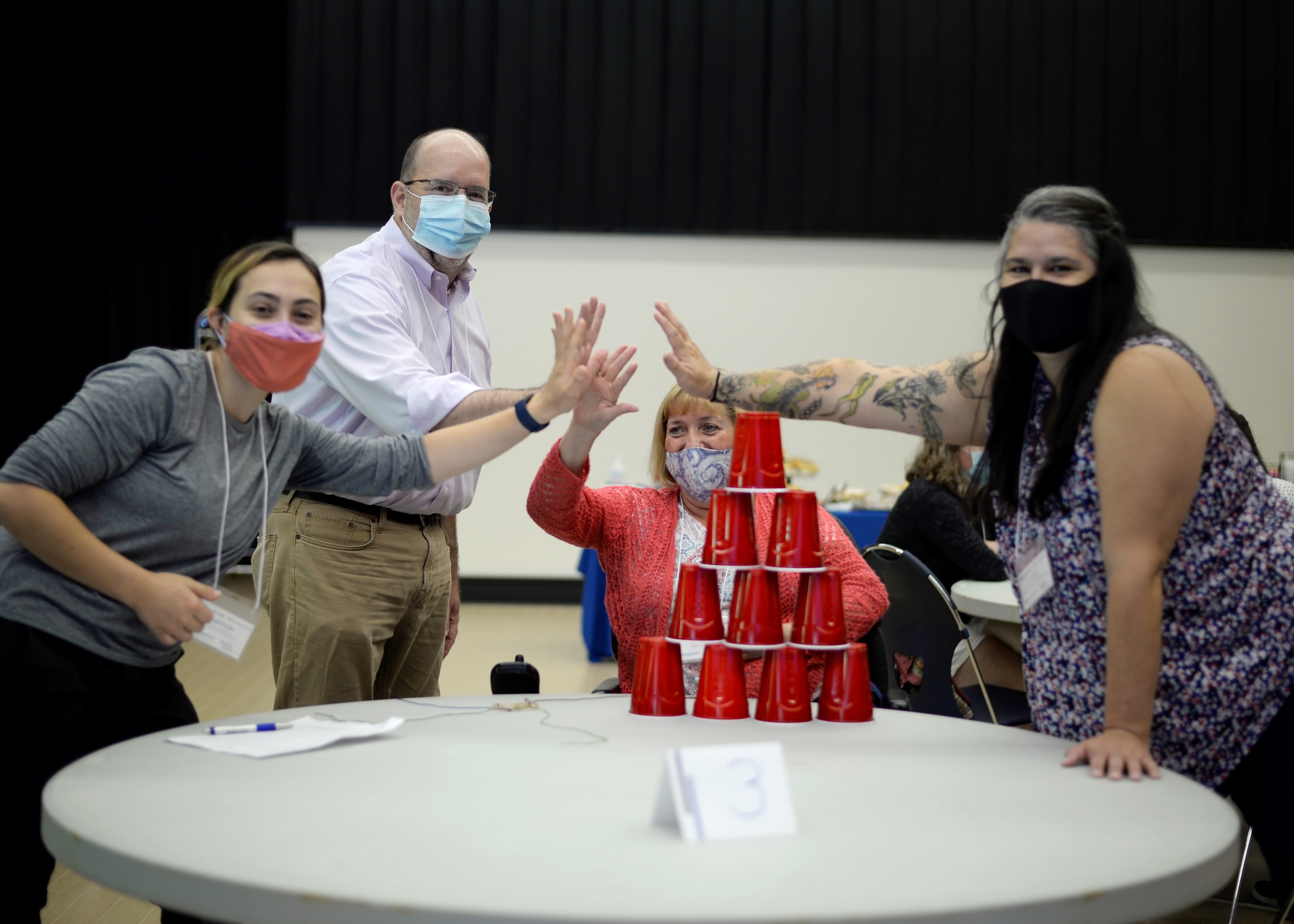 a meet and greet photo of 4 LEND faculty and staff, all wearing masks and high fiving