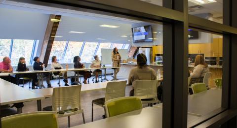 An educator lectures a class of adult learners.
