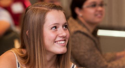 A young adolescent looks at someone off camera, engaged and smiling