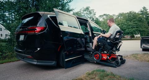 A man in a power wheelchair gets into an accessible minivan with a ramp through the side door.
