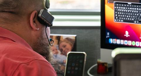 A man uses an assistive technology headset to use his computer.