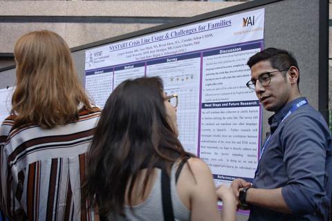 People talking in front of a research poster