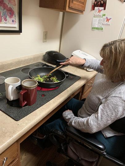 Kathy cooks at her accessible stove.