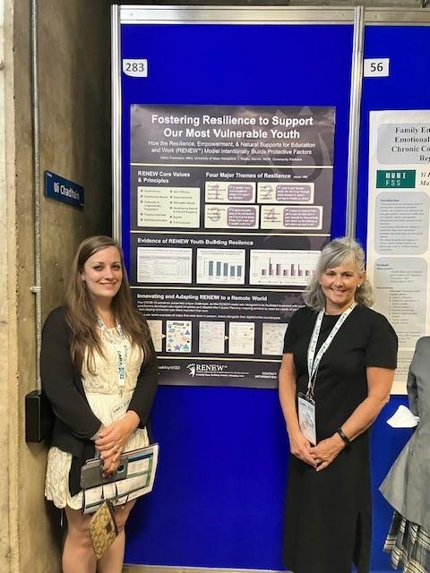 Kathy and Shelby stand in front of their poster "Fostering Resilience to Support Our Most Vulnerable Youth"