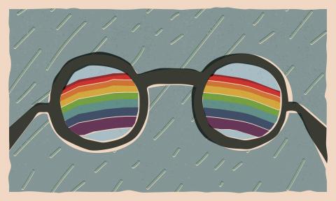 Black glasses with rainbows in the lenses surrounded by a rainy day