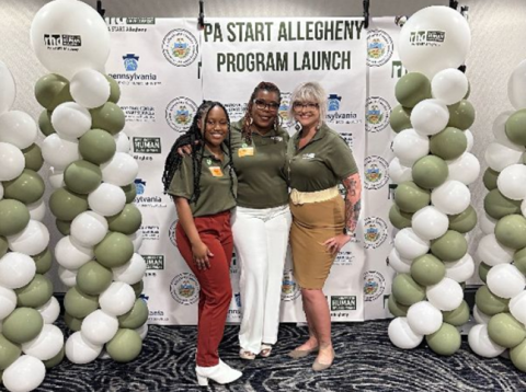 Three smiling women pose in front of a back drop that reads "PA START Allegheny Program Launch"