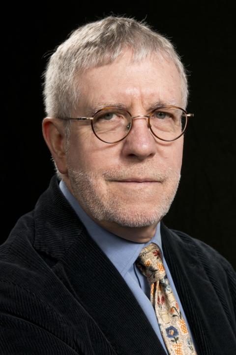 John O'Neill is a man with short gray hair and round glasses, wearing a suit and tie.