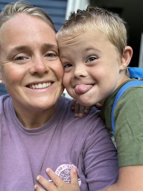 A mother and her young son with Downs Syndrome are happily posing for a selfie.