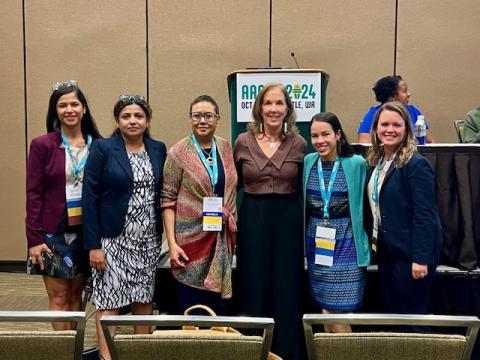 A group of people in professional attire posing for a group photo at a conference