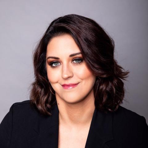 Julie Lago is a woman with dark hair wearing a blazer