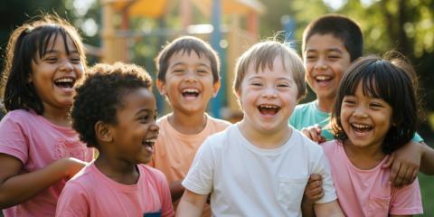 A diverse group of happy children smiling together for a photo on a playground.