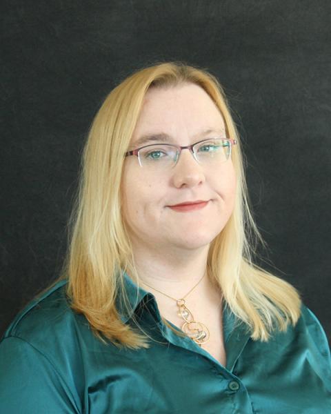 Jen Williams is a woman with mid-length blond hair, wearing read rimmed glasses and a teal colored blouse
