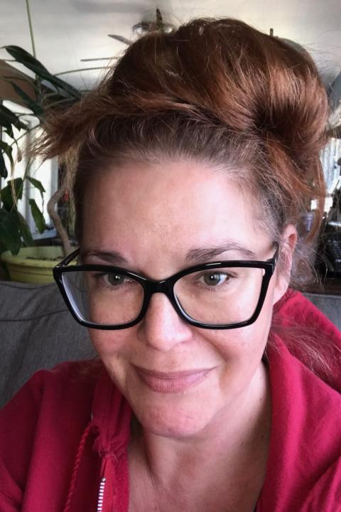Jiffy Lansing headshot, a woman with brown hair, styled up and dark rimmed glasses.